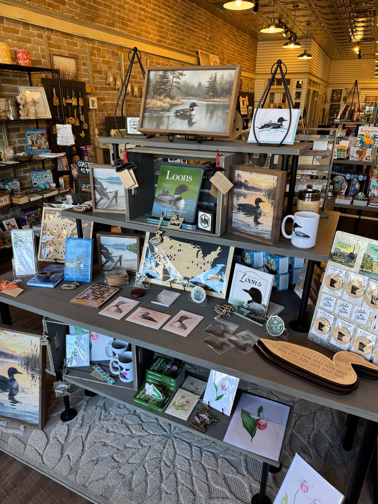 Display of various items including books, cards, and decorative objects in a store setting.